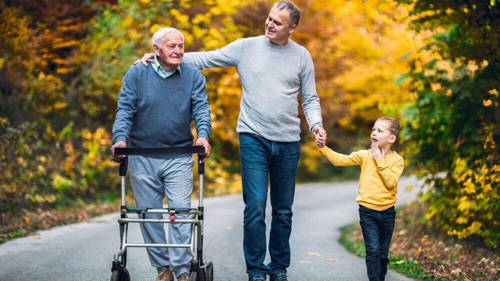 Elderly father adult son and grandson out for a walk in the park. Elderly father adult son and grandson out for a walk in the park.