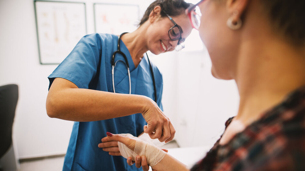 Ärztin behandelt Patientin und ist ihr zugewandt. Ärztin behandelt Patientin und ist ihr zugewandt.