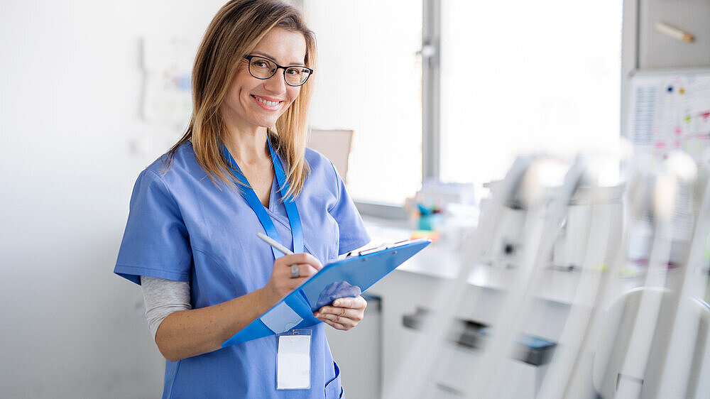 Dentalhygienikerin mit Klemmbrett in der Hand schaut in die Kamera. Dentalhygienikerin mit Klemmbrett in der Hand schaut in die Kamera.