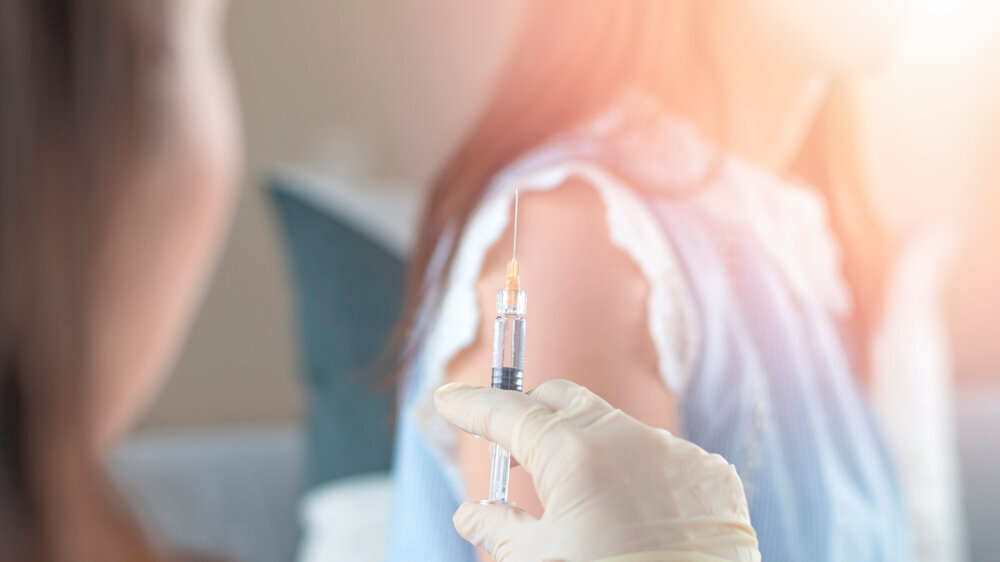 World immunization week and International HPV awareness day concept. Woman having vaccination for influenza or flu shot or HPV prevention with syringe by nurse or medical officer. HPV