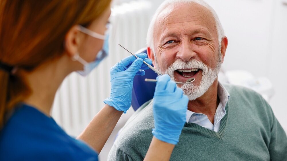 Zahnärztin beim Check-up eines älteren Patienten Zahnärztin beim Check-up eines älteren Patienten