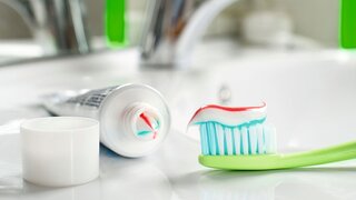 Toothbrush and toothpaste in the bathroom close up.