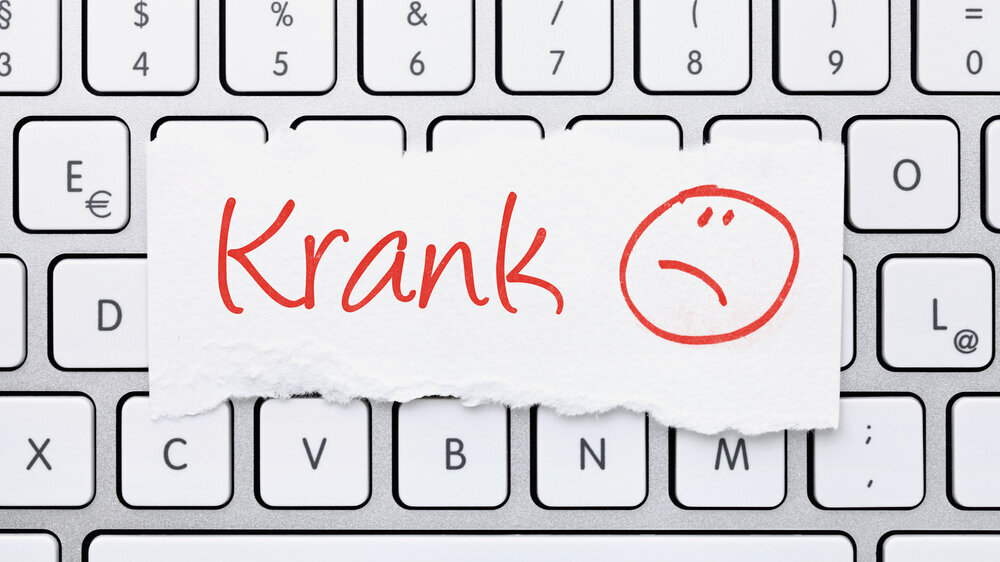 Notiz auf Computertastatur "Krank" Notiz auf Computertastatur "Krank"