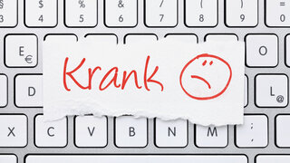 Notiz auf Computertastatur "Krank"