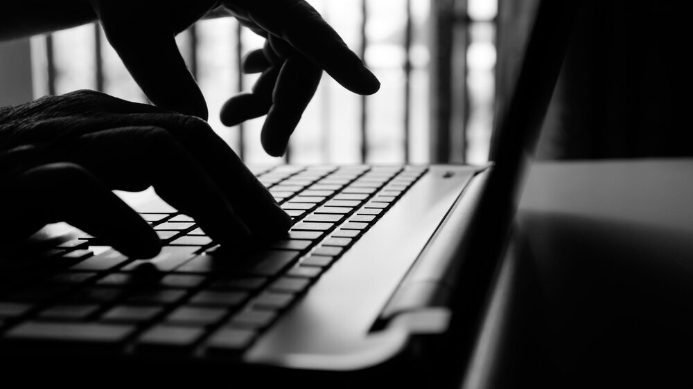 Die Hand eines Hackers oder Cyber-Kriminellen zeigt den Diebstab virtuteller Daten.