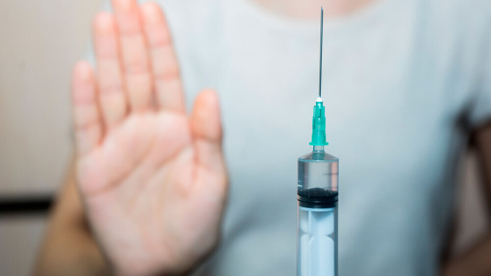 Gegen die einrichtigungsbezogene Impfpflicht: Erhobene Hand signalisiert nein zur Impfung. Gegen die einrichtigungsbezogene Impfpflicht: Erhobene Hand signalisiert nein zur Impfung.