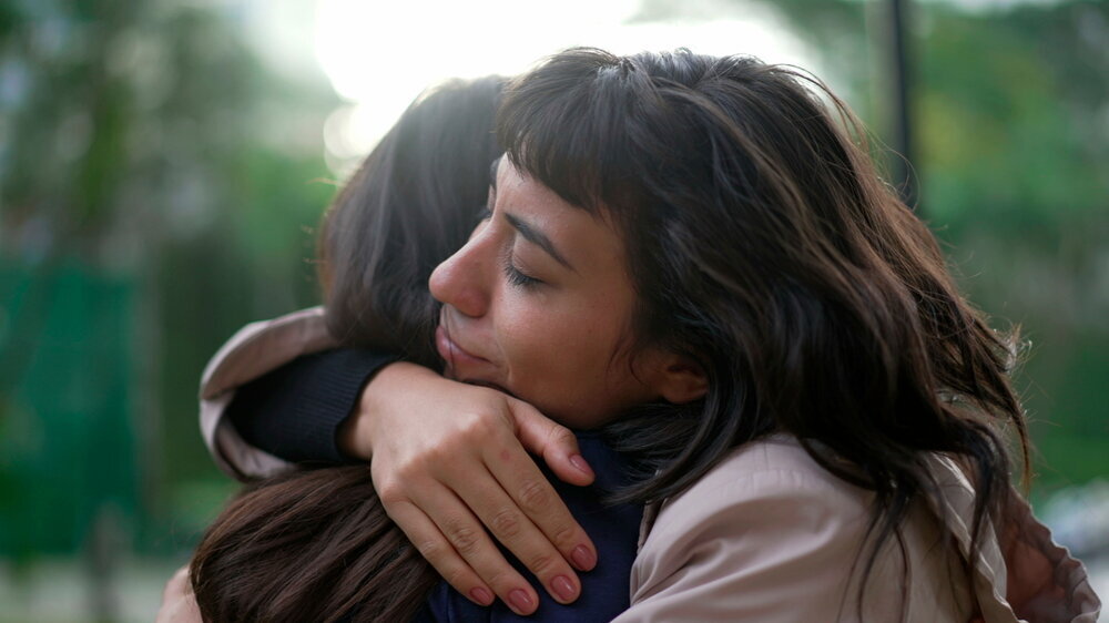 Zwei Frauen liegen sich in den Armen. Sie zeigen einander Empathie und Mitgefühl. Zwei Frauen liegen sich in den Armen. Sie zeigen einander Empathie und Mitgefühl.