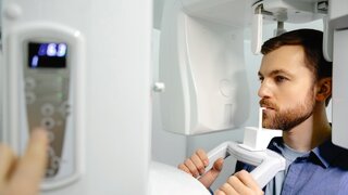 Panoramic image of teeth. A patient in a modern dental clinic takes a panoramic picture of the teeth. Prevention of dental diseases. Accurate diagnosis.Side view.
