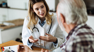 Hausärztin mit älterem Patienten