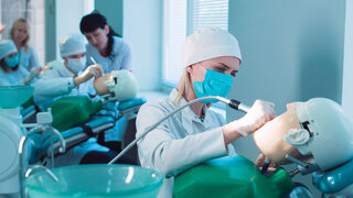 Zahnmedizinstudierende üben Behandlung an Phantomköpfen