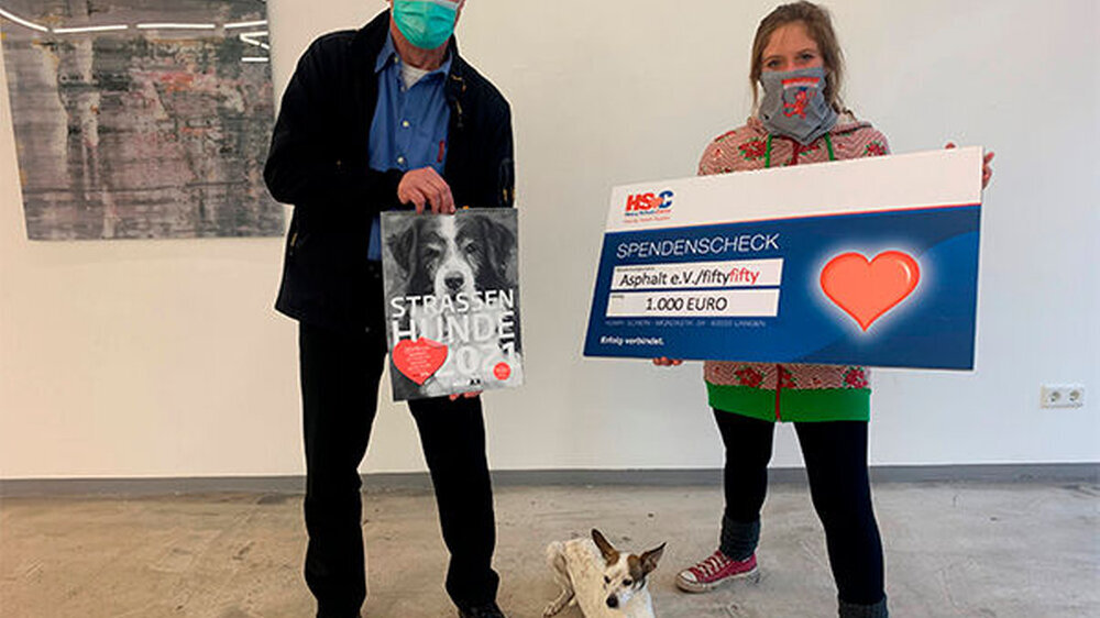 Detlev Fellmann, Gebietsverkaufsleiter NRW bei Henry Schein Dental Deutschland GmbH, und Julia von Lindern vom Straßenmagazin fiftyfifty bei der Scheckübergabe.