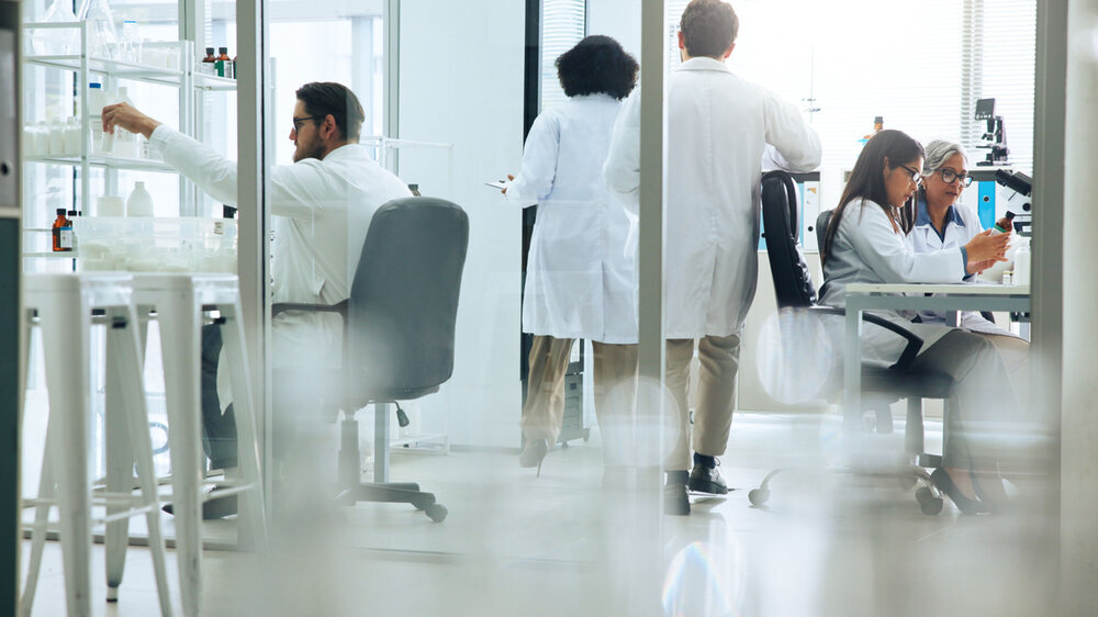 Busy, science and walking with people in laboratory together for medical or pharmaceutical research. Development, innovation and medicine with scientist team at work on clinical trial or experiment.