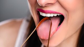 Frau reinigt ihre Zunge mit Reiniger