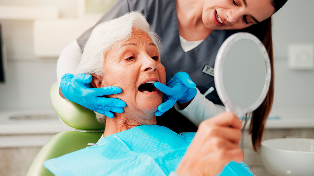Zahnarzt, ältere Frau und Beratung mit Spiegel für Zahnreinigung, Zahnimplantat oder Mundhygiene.
