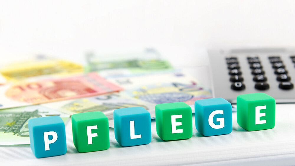 Geld (Euro) und Würfel mit Aufschrift Pflege Geld (Euro) und Würfel mit Aufschrift Pflege