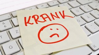 Zettel mit dem handschriftlichen Hinweis "Krank" liegt auf einer Tastatur