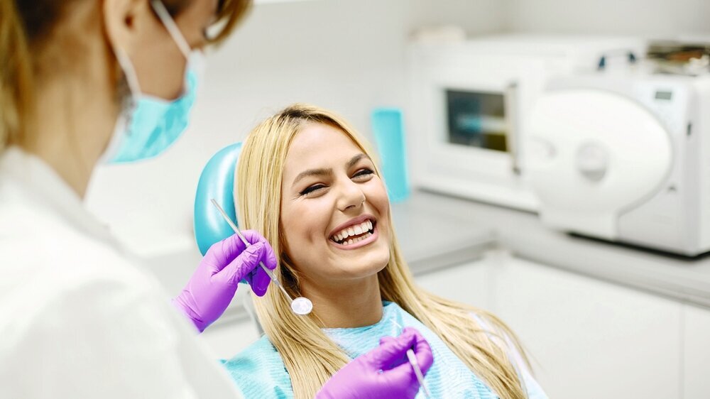 Female dentist and young woman patient in dentist office.