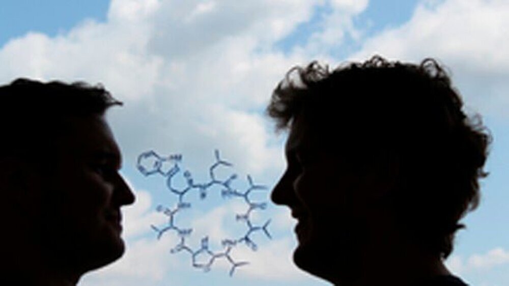 Die chemische Strukturformel des neu entdeckten Antibiotikums „Lugdunin“. Außerdem im Bild: die beiden Erstautoren Alexander Zipperer (links) und Martin Christoph Konnerth(rechts).