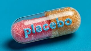 A medicine capsule reveals placebo in colorful sugar letters on a blue surface.