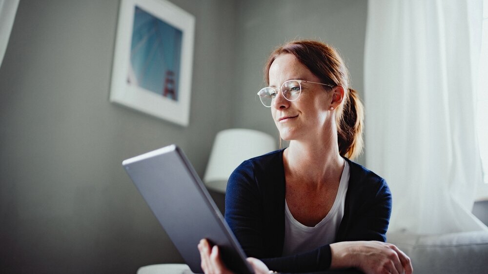 Rothaarige Frau arbeitet mit ihrem iPad