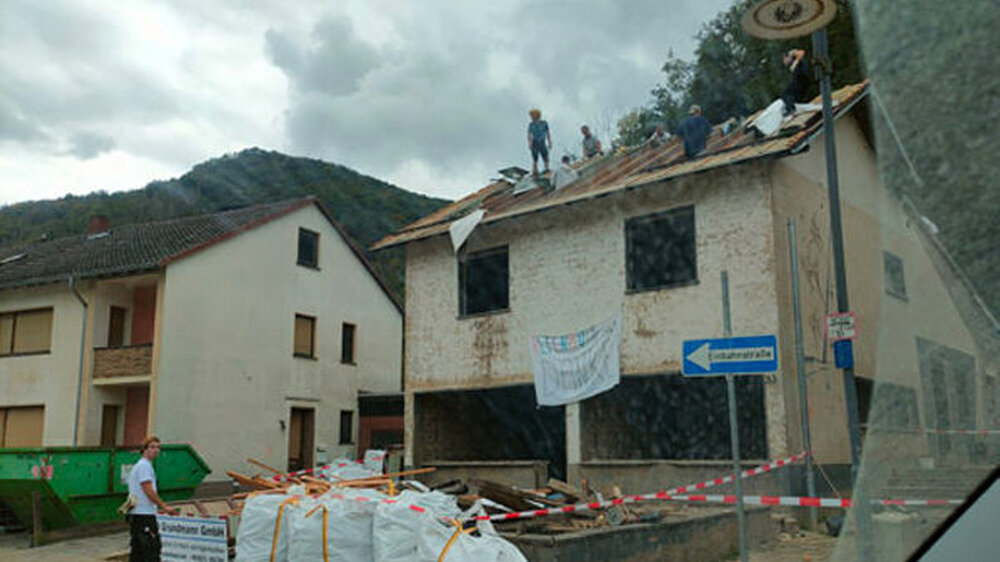 Zimmerleute auf einem entkernten Abriss-Haus. Die wiederverwendbaren Dachbalken werden abgebaut und gelagert.