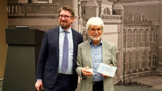 Der Präsident der European Federation of Periodontology, Prof. Moritz Kebschull (l.), zeichnet Seniorprof. Thomas Kocher mit dem EFP Distinguished Scientist Award aus.