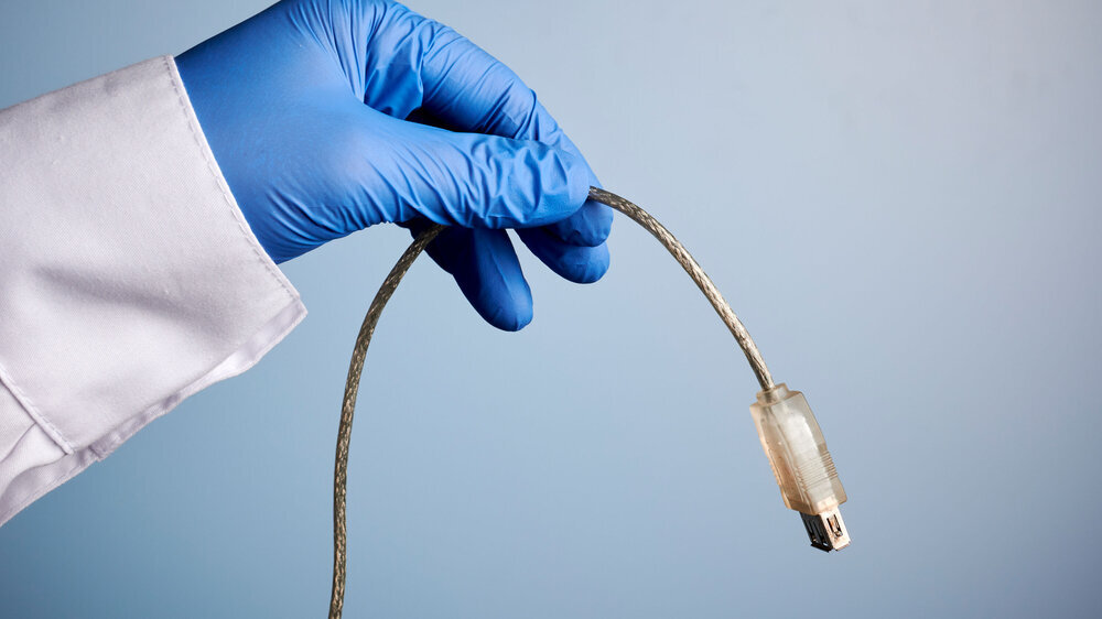 Arzt hält USB-Kabel in der Hand.