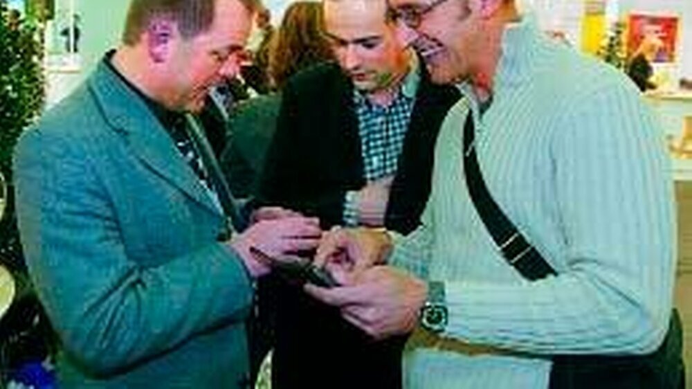 Messebesucher im Gespräch mit Tobias Bauer (l.) vom Kuratorium junger Zahnärzte (KjZ)
