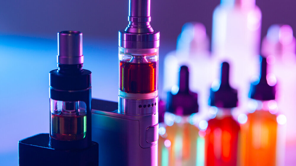 Electronic cigarettes on the background of Smoking accessories. Smoking gadgets. E-cigarettes. The concept of vaping. VAPE shop. Sale of accessories for Smoking electronic cigarettes.