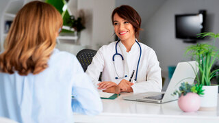 Ärztin im Gespräch mit Patientin in ihrer eigenen Praxis.