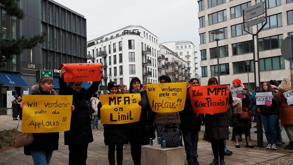 Bundesweite Streikaktion der MFA: Angestellte halten Schilder mit ihren Forderungen hoch.