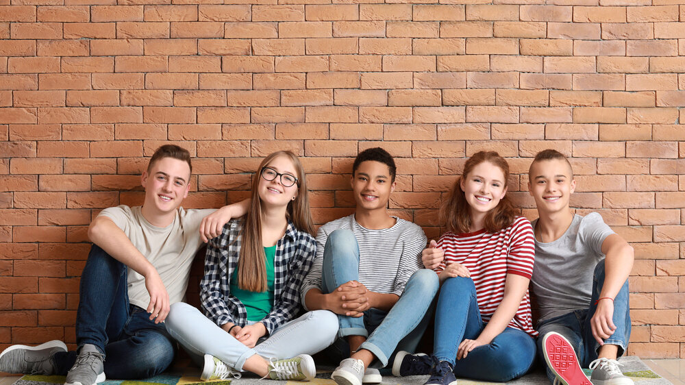 Gruppe Teenager auf dem Boden sitzend Gruppe Teenager auf dem Boden sitzend