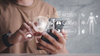 Mann hält Smartphone in der Hand und checkt seine Gesundheitsdaten.