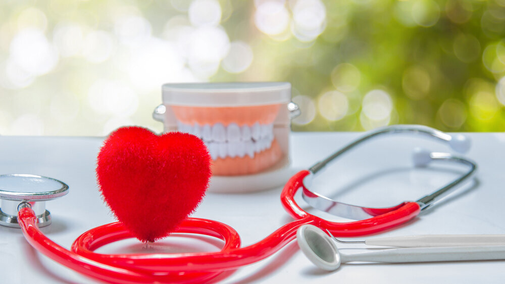 Red heart and health care equipment, teeth and mouth on the background green blurred. Herz und Zähne