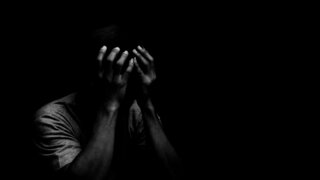 Man sitting alone felling sad worry or fear and hands up on head on black background