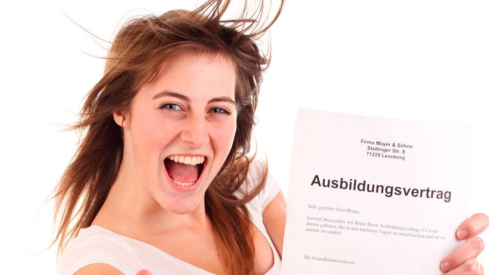 Junges Mädchen hält Ausbildungsvertrag in der Hand
