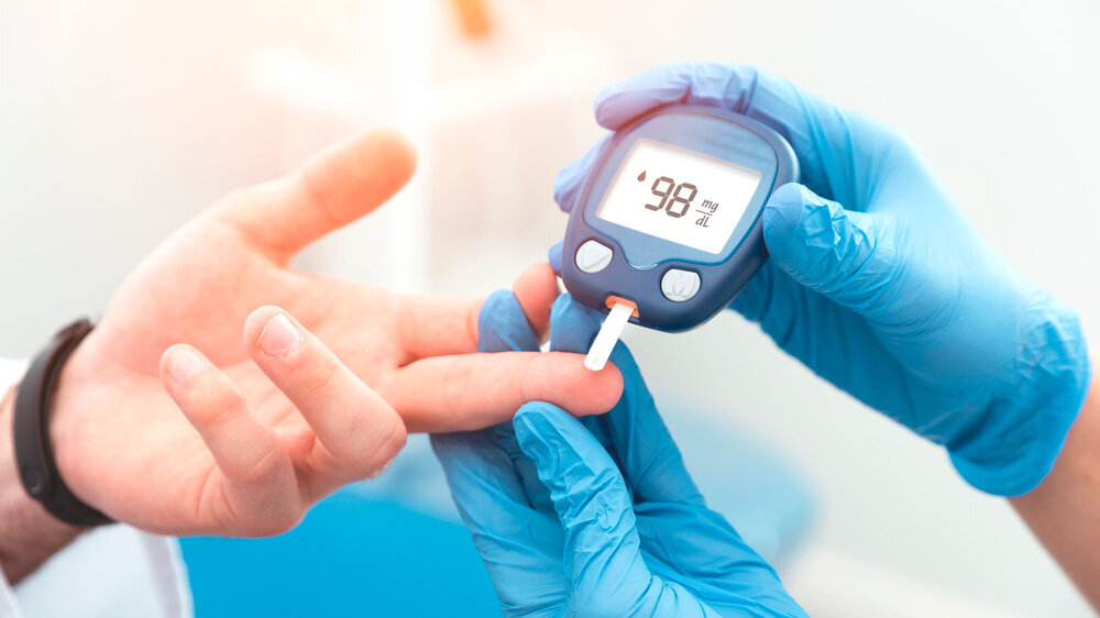 Doctor checking blood sugar level with glucometer Arzt überprüft den Blutzuckerspiegel mit Glukometer.