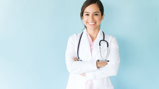 Junge Ärztin im Arztkittel und mit Stethoskop.