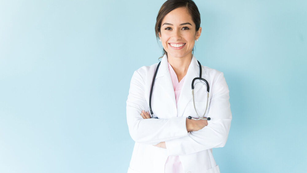 Junge Ärztin im Arztkittel und mit Stethoskop.