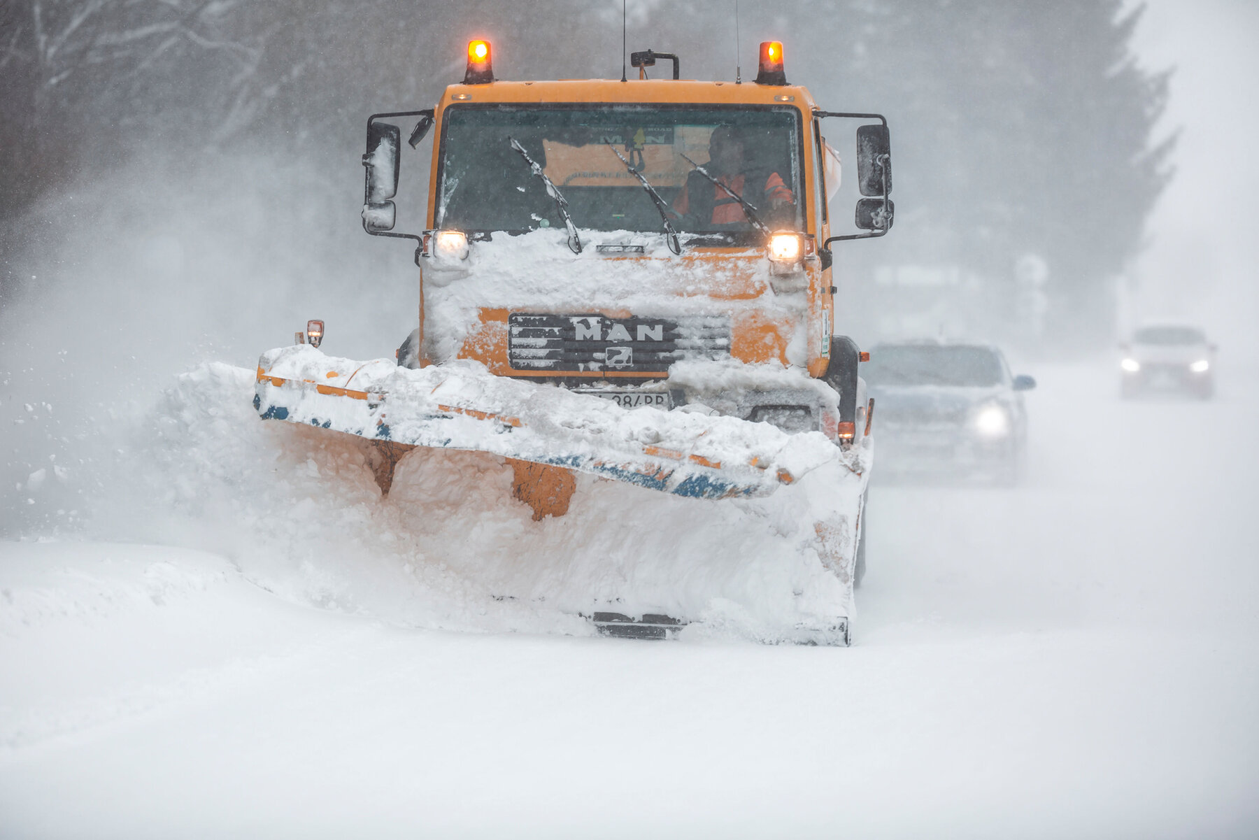 Liptov, Slovakia - JANUARY 30, 2022. The snow plow clears the way for the cars behind it.