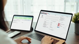Woman using digital laptop and tablet with smartphone on the table in house. Blank screen for advertising