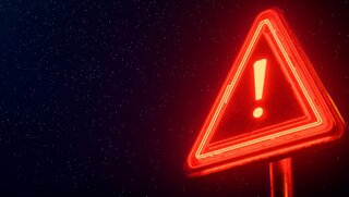 Rotes Neon-Warnschild auf schwarzem Hintergrund