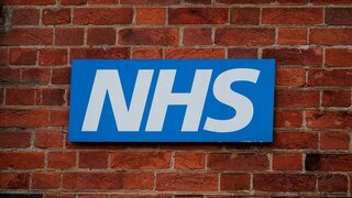 Blaues und weißes NHS-Zeichen an einer Backsteinmauer in York, Großbritannien.