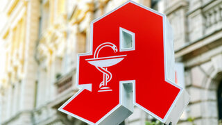 Logo Apotheke vor Häuserfassade