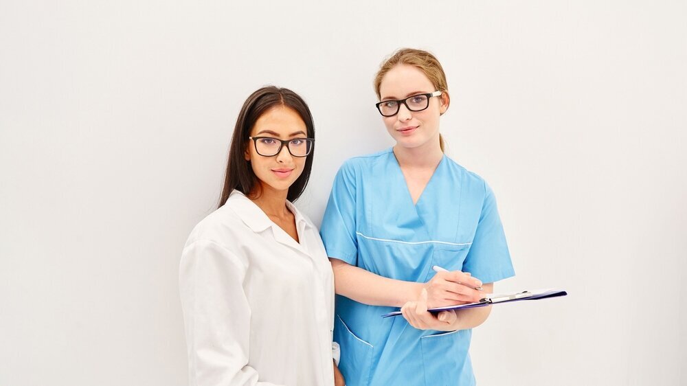Two women as clinic staff with clipboard Two young women as clinic staff with clipboard in the beauty clinic
