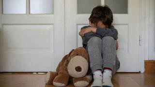 view of a child victim of child abuse in his room