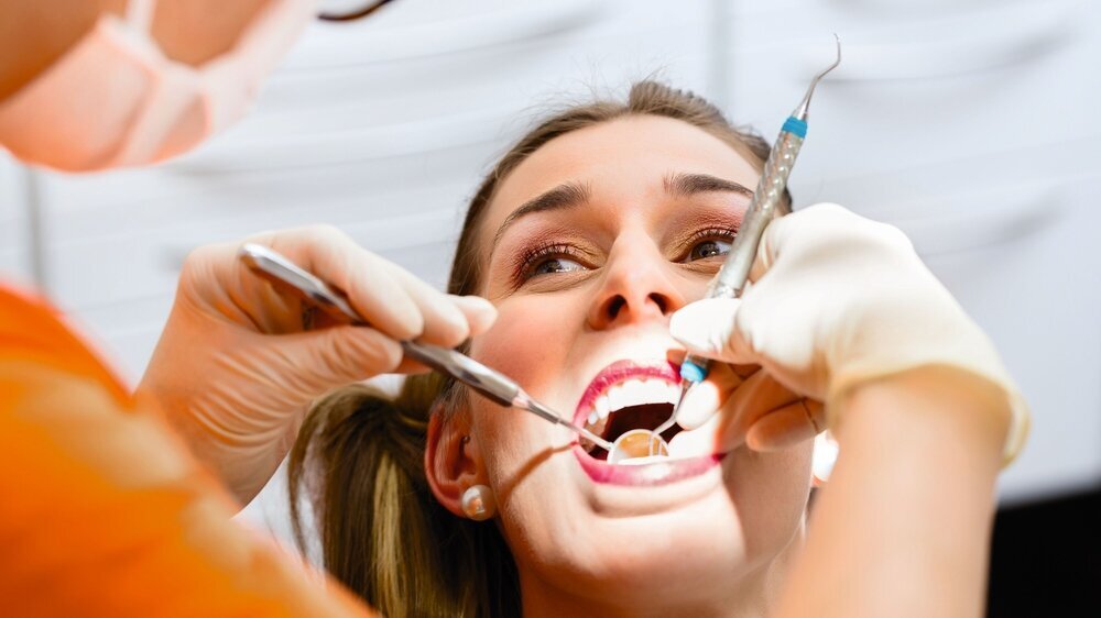 Patient having deep dental tooth cleaning at dentist
