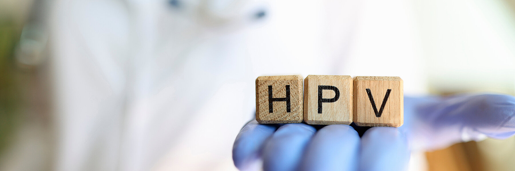 Female practitioner hand holding wooden cubes with word hpv Close-up of female practitioner hand holding wooden cubes with word hpv. Medicine and human papillomavirus acronym concept