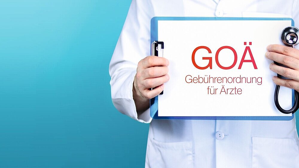 GOÄ (Gebührenordnung für Ärzte). Arzt hält blaues Schild mit Papier. GOÄ (Gebührenordnung für Ärzte). Arzt hält blaues Schild mit Papier.