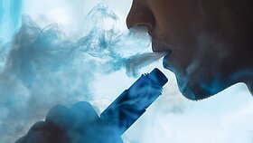 vaping man holding a mod. A cloud of vapor.